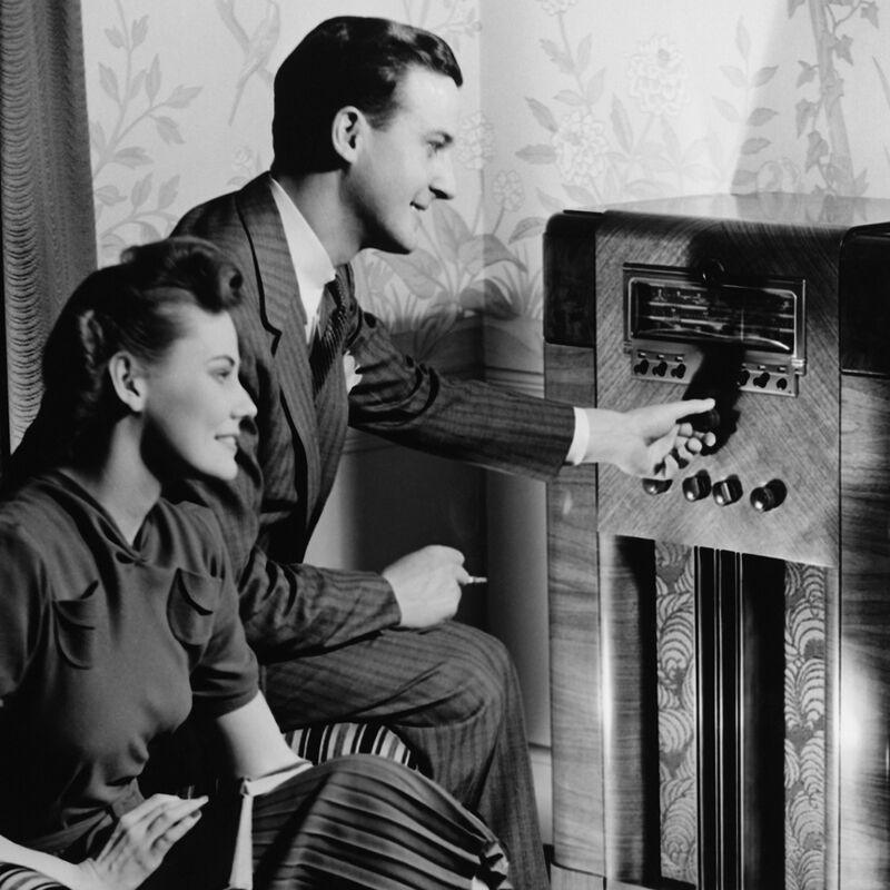 A couple listening to a console radio in the 1940s